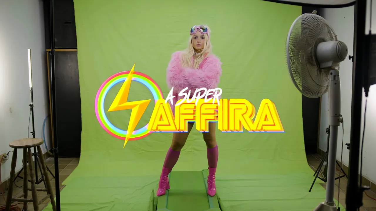 A Super Saffira dançando diante do pano de chroma verde do estúdio, com o logo A SUPER SAFFIRA na tela.